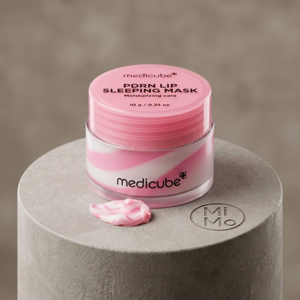 ظرف ماسک شب لب پیدیآران مدی کیوب با طرح مارپیچ صورتی و سفید، با نوشته 'Moisturizing care' و '10 g / 0.35 oz.' روی درب آن. مقدار کمی از ماسک در کنار ظرف روی سطح قرار دارد.